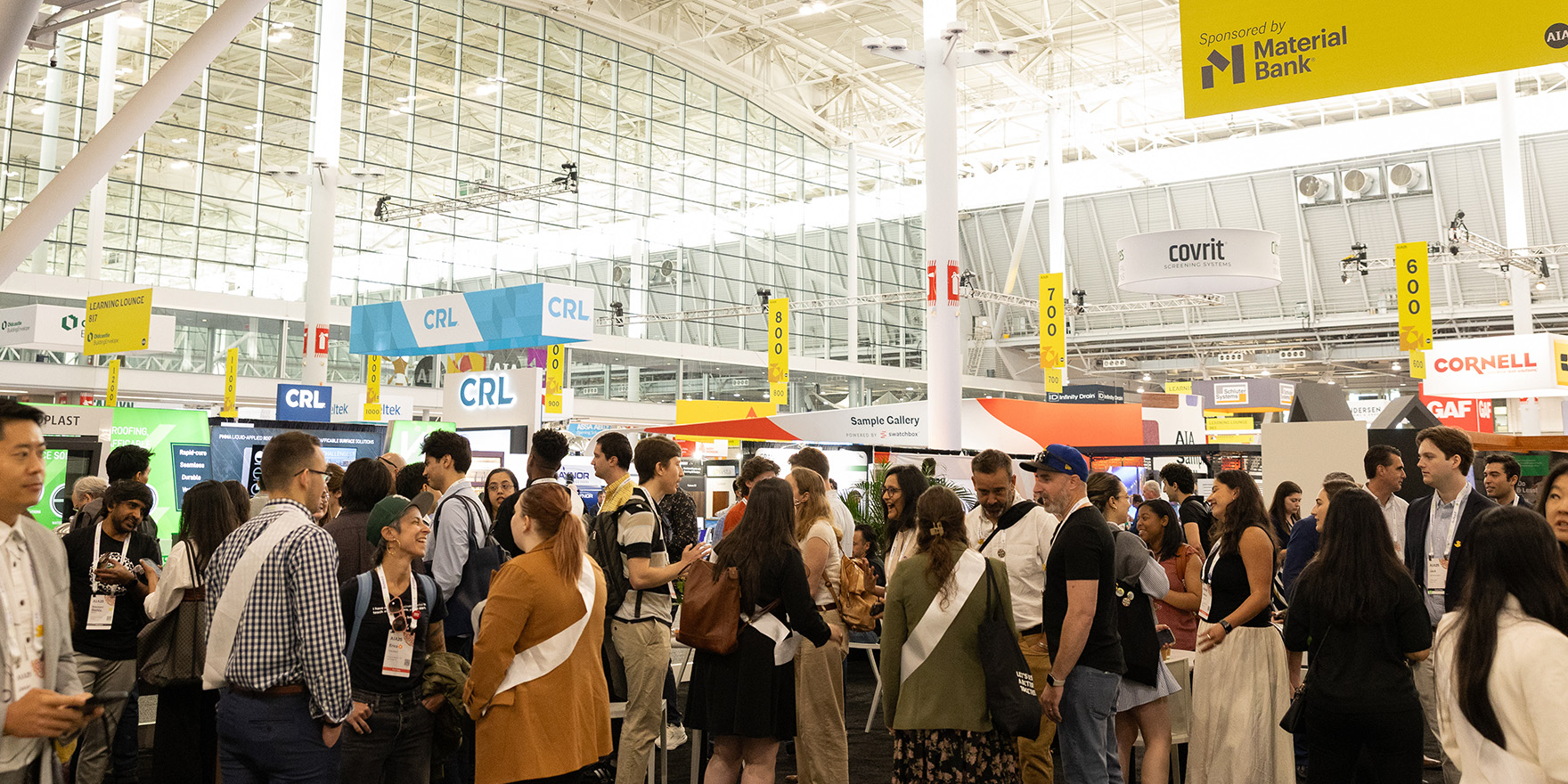 Architects and design professionals networking on the exhibit hall floor during the Conference on Architecture and Design.